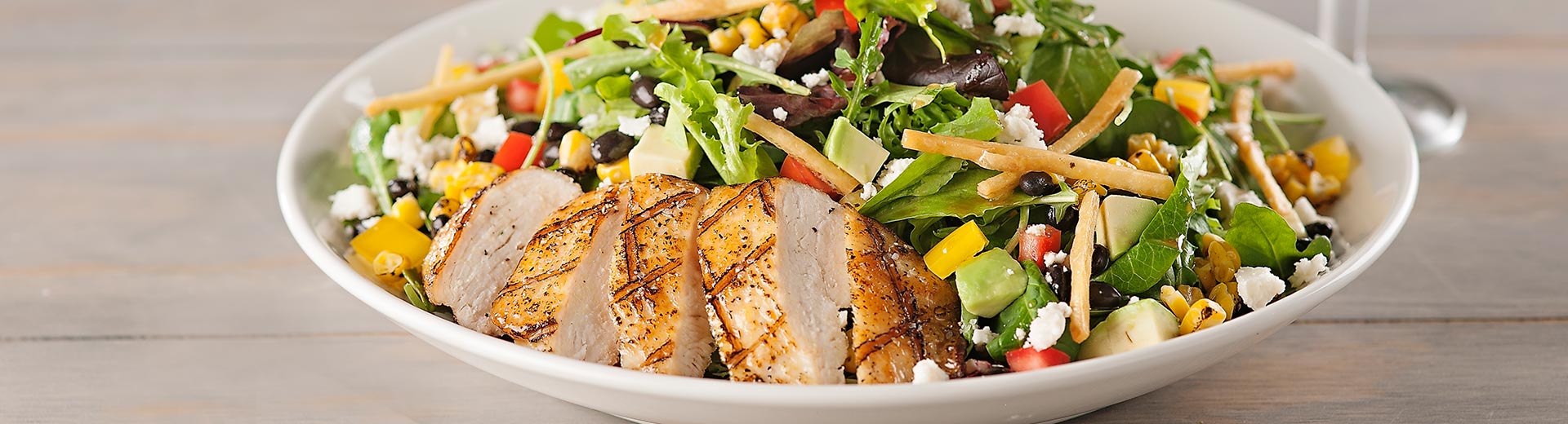 Healthy grilled chicken salad with a variety of toppings